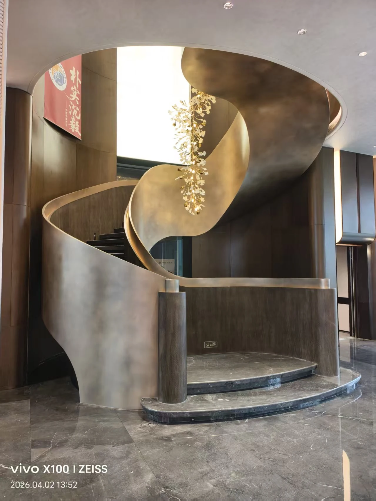 Champagne-coloured helical staircase with continuous curved sides at Jiuzhangfu in Changsha, China.