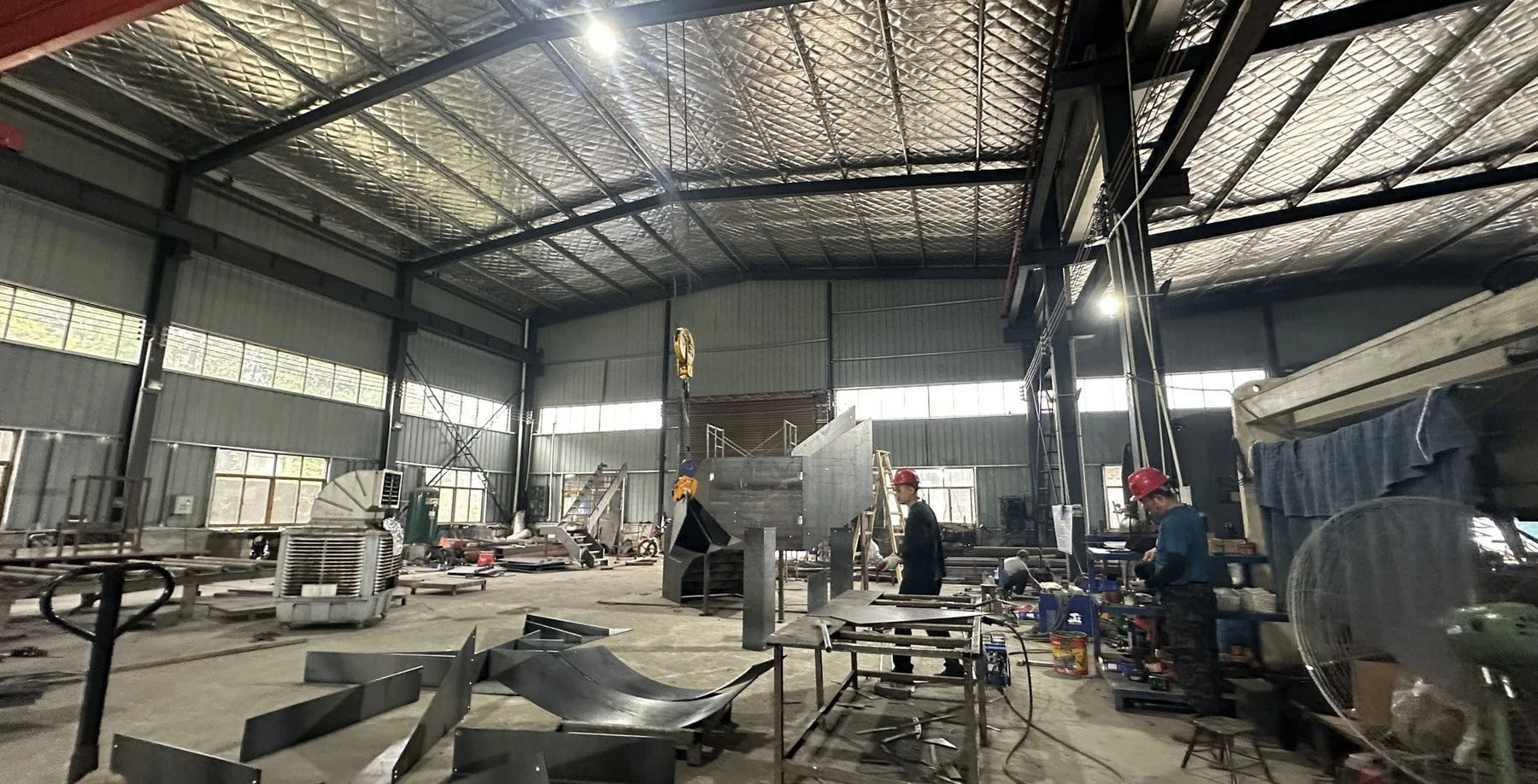 Steel staircase components and a partly assembled stair in the BUBUJIA workshop.
