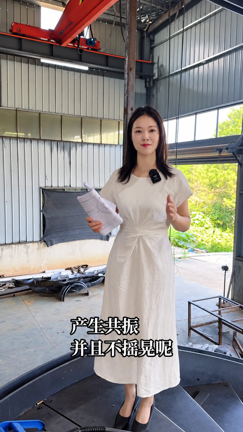 白裙人物站在旋转钢梯踏步上，双手自然示意，脚下可见转向排列的钢踏步。